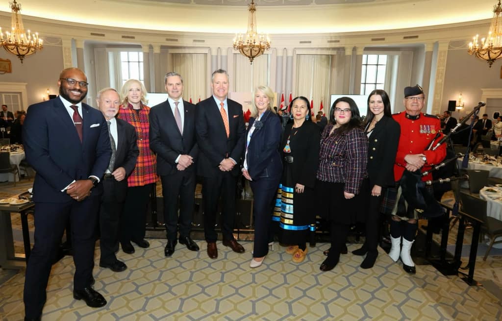 Club leaders and guests standing together on a red carpet